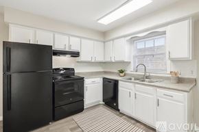 Nashville apartment for rent - A kitchen with black appliances and white cabinets.