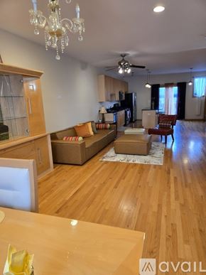 Chicago townhouse for rent - A living room with a couch, chairs, and a dining table.
