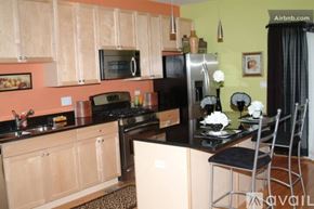 Chicago townhouse for rent - A kitchen with wooden cabinets and black appliances.
