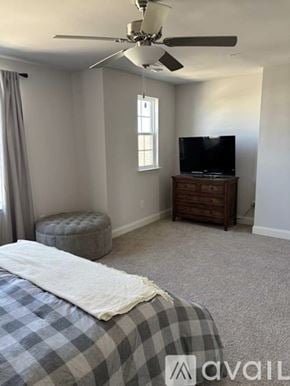 Spring Hill townhouse for rent - A bedroom with a bed, a television, and a window.