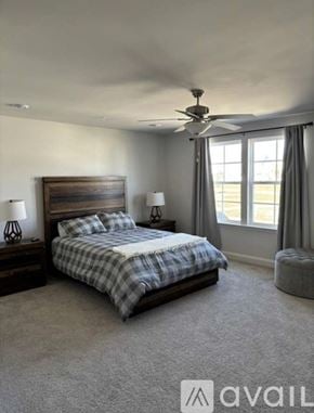 Spring Hill townhouse for rent - A bedroom with a bed, two lamps, and a ceiling fan.