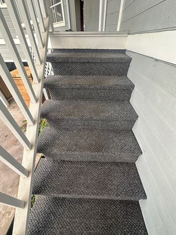 Kailua-Kona apartment for rent - A staircase with a grey carpeted runner and a white wall on the side.