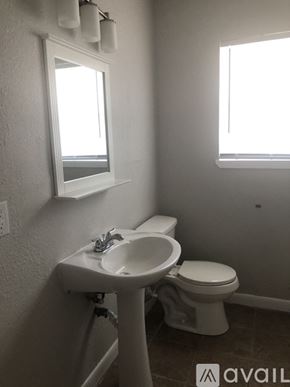 Corpus Christi apartment for rent - A bathroom with a toilet, sink, and window.