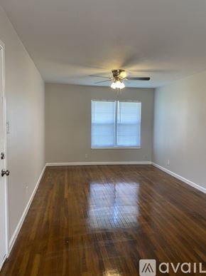 Corpus Christi apartment for rent - A room with wooden floors and a ceiling fan.