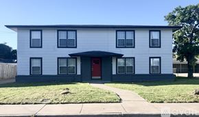 Corpus Christi apartment for rent - A white house with a red door and black windows.