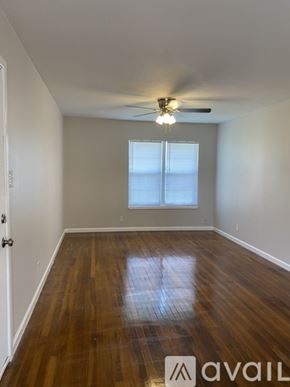 Corpus Christi apartment for rent - A room with wooden floors and a ceiling fan.