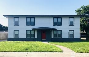 Corpus Christi apartment for rent - A white house with a red door and a grey front yard.