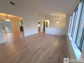 Simsbury house for rent - A spacious room with wooden flooring and large windows.