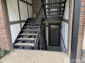 Nashville condo for rent - A staircase with a black railing and steps leading to a door.