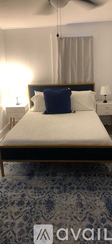 Calais apartment for rent - A bedroom with a bed, two lamps, and a ceiling fan.