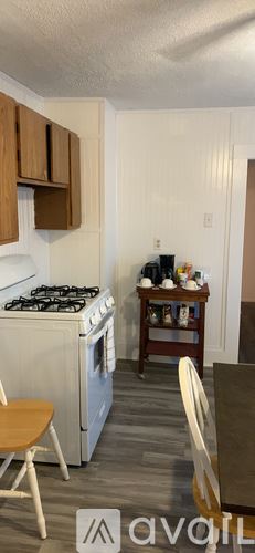 Calais apartment for rent - A kitchen with a white stove top oven and wooden cabinets.