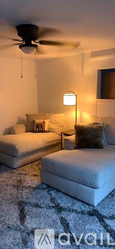Calais apartment for rent - A living room with a white couch and a ceiling fan.