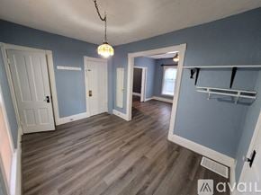 Lockport apartment for rent - A room with a wooden floor and a hanging light fixture.