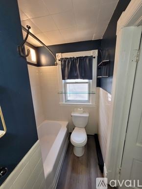 Lockport apartment for rent - A bathroom with a white toilet and a white bathtub.