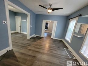 Lockport apartment for rent - A room with a ceiling fan and wooden flooring.