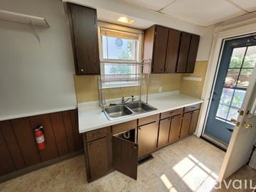 Lockport apartment for rent - A kitchen with wooden cabinets and a white countertop.