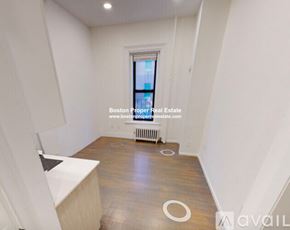 Boston apartment for rent - A room with wooden flooring and a window with a view of a city.