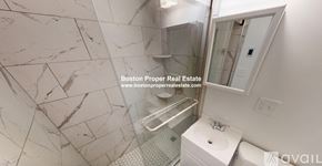Boston apartment for rent - A marble bathroom with a walk-in shower and a toilet.