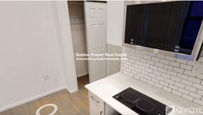 Boston apartment for rent - A kitchen with a white countertop and a black stove top oven.