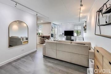 Arlington Heights condo for rent - A spacious living room with a beige sofa and a large mirror on the wall.