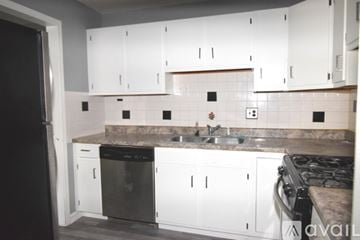 Willowbrook condo for rent - A kitchen with white cabinets and a black refrigerator.