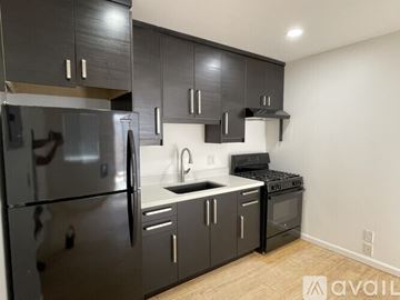 Long Beach apartment for rent - A kitchen with black cabinets and stainless steel appliances.