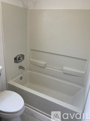 Long Beach apartment for rent - A white toilet sits next to a bathtub in a bathroom.