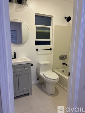 Long Beach apartment for rent - A bathroom with a toilet, sink, and mirror.