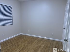 Long Beach apartment for rent - A room with wooden flooring and a white door.