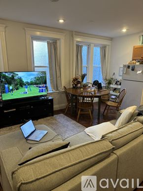 Boston apartment for rent - A living room with a couch, a television, a dining table, and chairs.