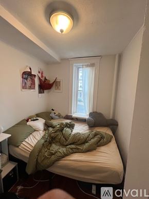 Boston apartment for rent - A bedroom with a bed covered in a green blanket.