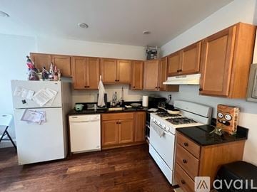 Boston apartment for rent - A kitchen with wooden cabinets and a white fridge.