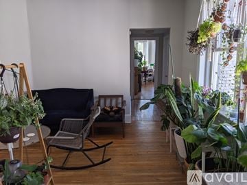 Boston apartment for rent - A living room with a black sofa and a wooden rocking chair.