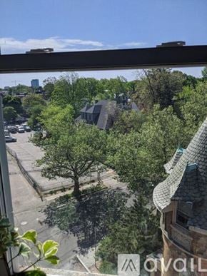 Boston apartment for rent - A view from a window looking out at a tree, a building, and a parking lot.