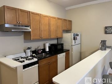 Boston apartment for rent - A kitchen with wooden cabinets and a white counter.