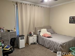 Boston apartment for rent - A bedroom with a bed, desk, chair, and window with curtains.