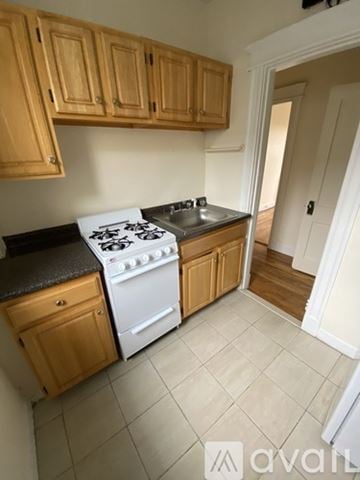 Boston apartment for rent - A kitchen with wooden cabinets and a white stove top oven.