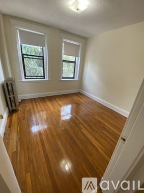 Boston apartment for rent - A room with wooden floors and two windows.