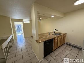 Boulder condo for rent - A kitchen with a black dishwasher and wooden cabinets.