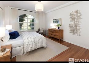 San Francisco condo for rent - A bedroom with a large bed, a nightstand, and a wall art piece.