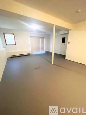 Danbury apartment for rent - A spacious room with a window and a door leading to another room.
