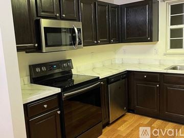 Myrtle Beach house for rent - A kitchen with black cabinets and stainless steel appliances.