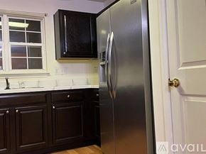 Myrtle Beach house for rent - A kitchen with a stainless steel refrigerator and wooden cabinets.