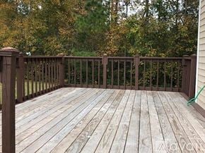 Myrtle Beach house for rent - A wooden deck with a railing and trees in the background.