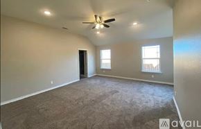 San Angelo house for rent - A spacious room with a ceiling fan and two windows.