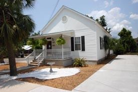Pensacola apartment for rent - A white house with a porch and a tree in front.