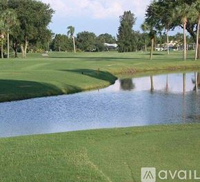 Port Charlotte apartment for rent - A golf course with a pond and trees in the background.
