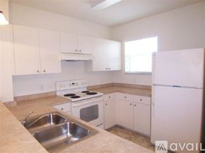Port Charlotte apartment for rent - A kitchen with white cabinets and appliances.