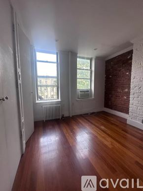New York apartment for rent - A room with wooden floors and a brick wall.