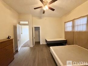 Raton apartment for rent - A room with a bed, a dresser, and a ceiling fan.